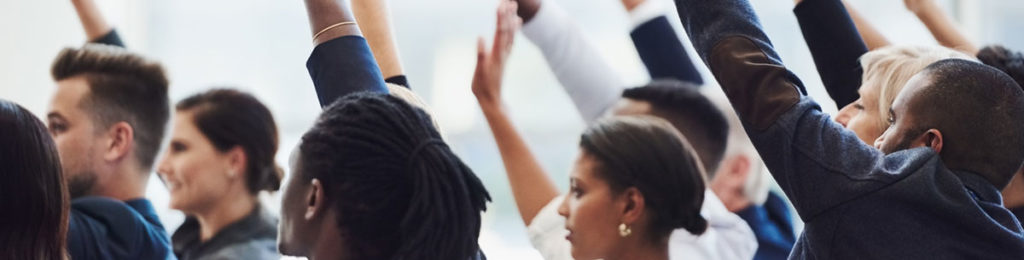 People raising their hands in a meeting