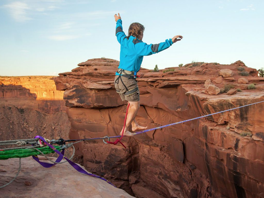 Man walking on a tight rope across the Grand Canyon