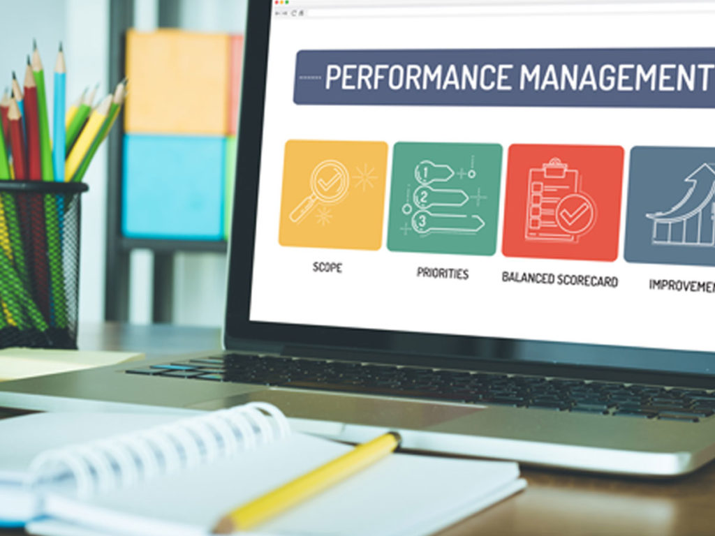 Laptop on a desk showing a performance management dashboard