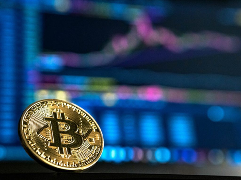 Bitcoin in front of computer screen