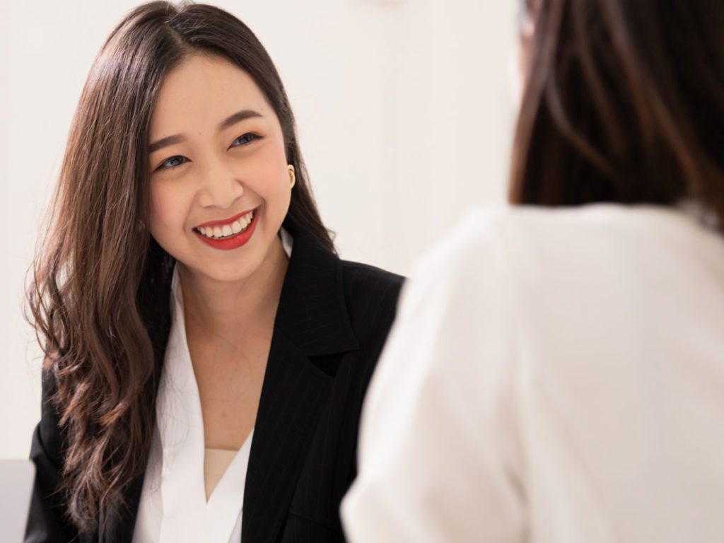 Woman smiling while speaking with teammate