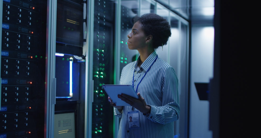 Woman looking at large main frame computer board