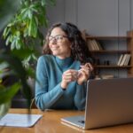 office worker in front of laptop staring to the side