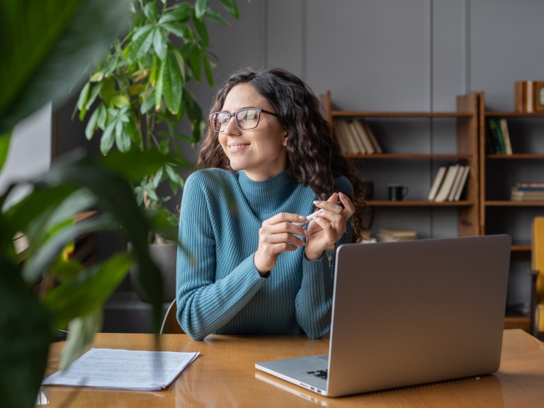 office worker in front of laptop staring to the side