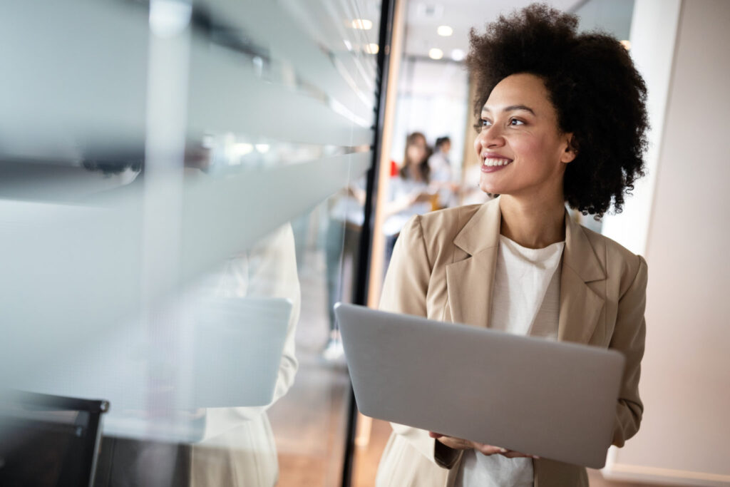 businesswoman holding a laptop and smiling