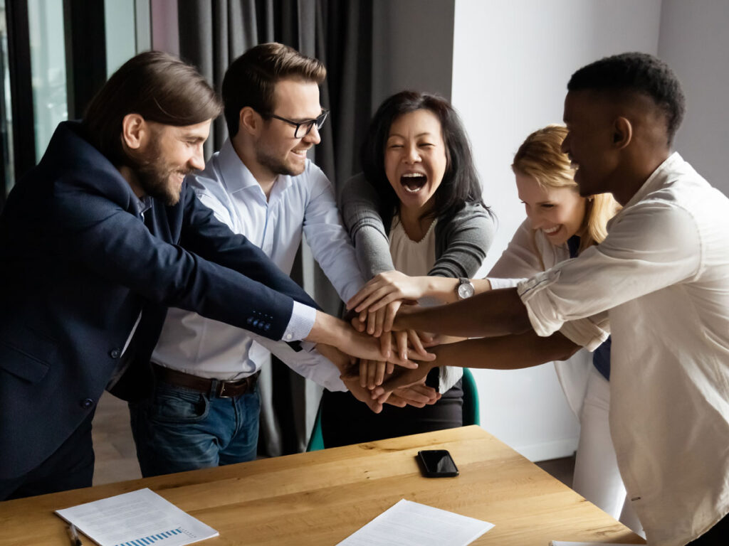 employees in office holding fists together