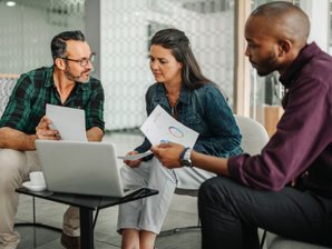 3 employees looking over data on a computer