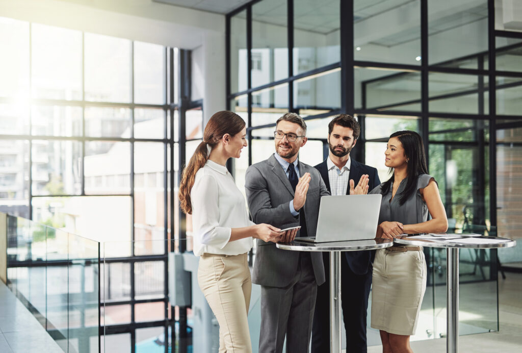 3 employees standing in an office with glass walls