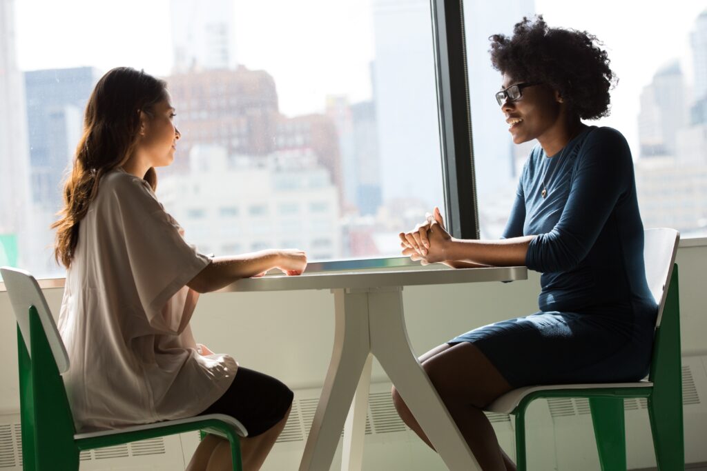 two women in an office table talkling