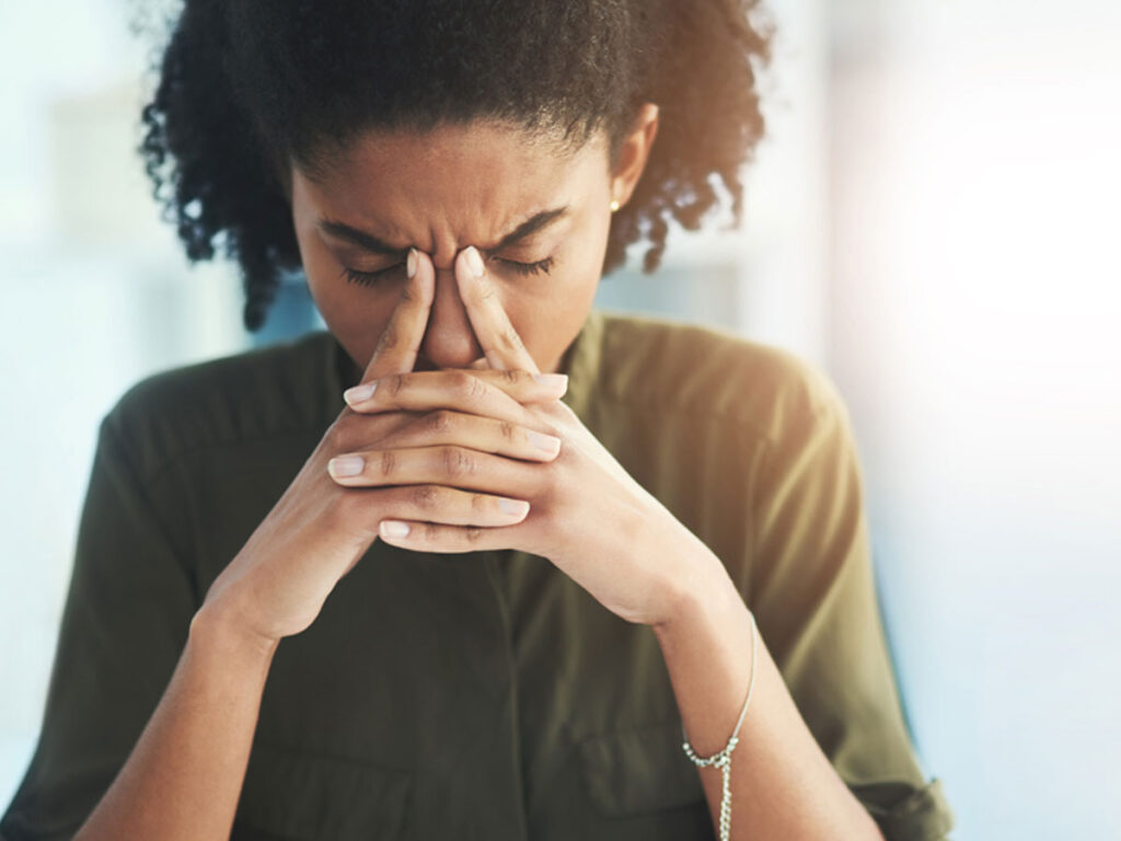 woman employee looking down into clasped hands.