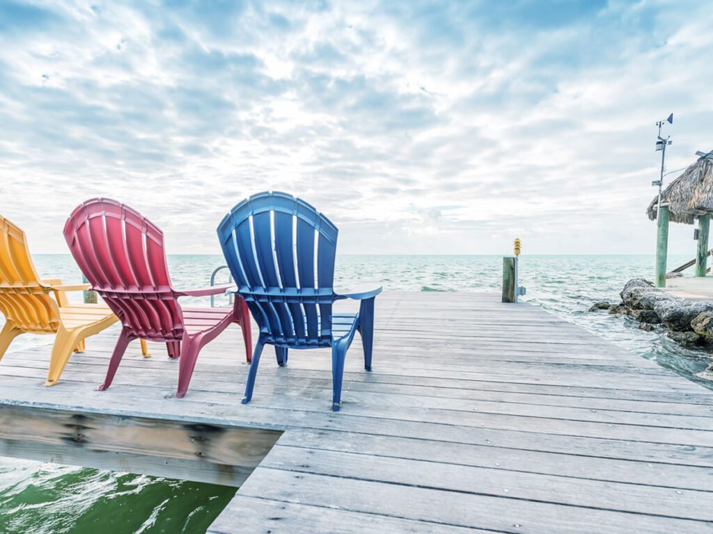 lounge chairs on a dock near water