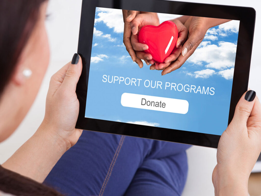 woman holding an ipad with a donation screen